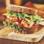 turkey meat sandwich with lettuce, cheese and tomato