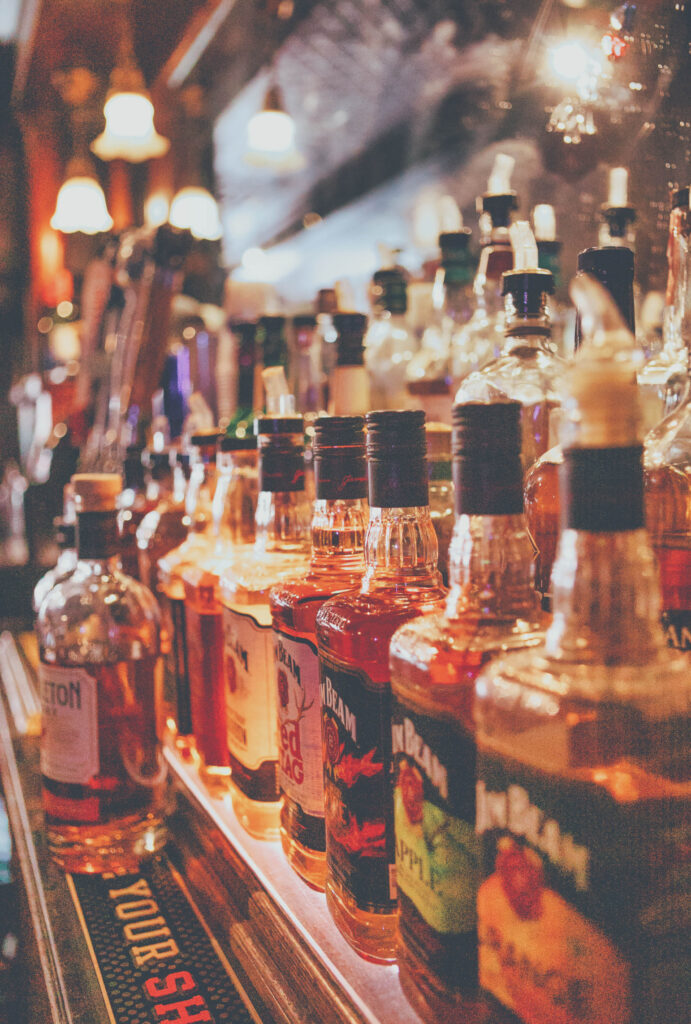 A line up of beautiful liquor bottles displayed on an old time bar back