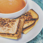a comfort food of grilled cheese with tomato soup
